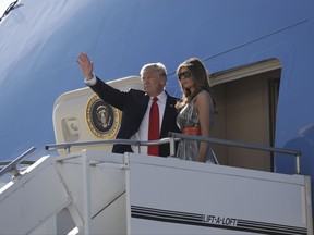 President Donald Trump, accompanied by first lady Melania Trump, waves as they board Air Force One in Hamburg, Germany, Saturday, July 8, 2017, en route to Washington following the G20 Summit.  (AP Photo/Evan Vucci)