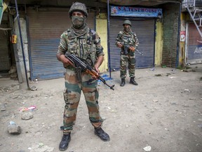 Indian army soldiers stands guard at the site of shootout in Batengoo about 50 Kilometres (31.25 miles) south Srinagar, Indian controlled Kashmir, Tuesday, July 11, 2017. Gunmen sprayed bullets on a passenger bus bringing Hindu pilgrims back from a cave shrine in Indian-controlled Kashmir on Monday, killing at least seven of them, including five women, and wounding 14 others, police said. (AP Photo/Dar Yasin)