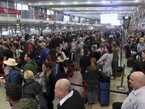 People crowd a terminal at Sydney's domestic airport as passengers are subjected to increased security, in Sydney, Australia, Monday, July 31, 2017. Security remains heightened in airports around Australia with more intense screening of luggage after law enforcement officials said they had thwarted a plan to bring down an airliner.