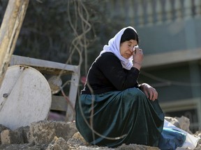 An Iraqi woman from the Yazidi community cries at her house, that was badly damaged by Islamic State fighters, during their occupation of Bashiqa, east of Mosul.