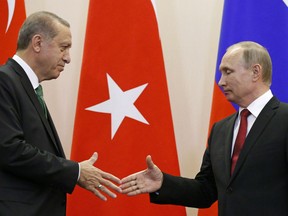 Russian President Vladimir Putin, right, and Turkish President Recep Tayyip Erdogan shake hands after a news conference following their talks in Putin's residence in the Russian Black Sea resort of Sochi.