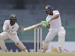 Sri Lanka's Asela Gunaratne plays a shot as Zimbabwe's Regis Chakabva watches during the final day of the only test cricket match between Sri Lanka and Zimbabwe in Colombo, Sri Lanka, Tuesday, July 18, 2017. (AP Photo/Eranga Jayawardena)