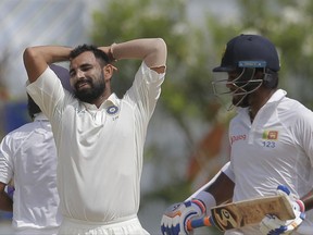 India's Mohammed Shami, left, reacts after delivering a ball as Sri Lankan batsman Dimuth Karunarathne runs between wickets during the fourth day's play of the first test cricket match between India and Sri Lanka in Galle, Sri Lanka, Saturday, July 29, 2017. (AP Photo/Eranga Jayawardena)