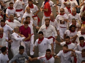 Revellers run in front of Cebada Gago fighting bulls during the first running of the bulls at the San Fermin Festival, in Pamplona, northern Spain, Friday, July 7, 2017. Revellers from around the world flock to Pamplona every year to take part in the eight days of the running of the bulls. (AP Photo/Alvaro Barrientos)