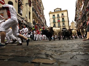 Revellers run in front of Fuente Ymbro's fighting bulls during the running of the bulls at the San Fermin Festival, in Pamplona, northern Spain, Monday, July 10, 2017. Revellers from around the world flock to Pamplona every year to take part in the eight days of the running of the bulls. (AP Photo/Alvaro Barrientos)