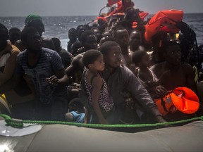 Migrants wait to be rescued by aid workers of Spanish NGO Proactiva Open Arms in the Mediterranean Sea, about 15 miles north of Sabratha, Libya on Tuesday, July 25, 2017. (AP Photo/Santi Palacios)
