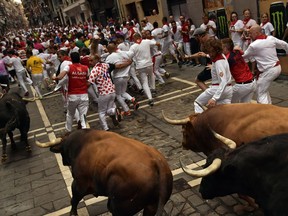 Revellers run next to Nunez del Cuvillo's fighting bulls during the running of the bulls at the San Fermin Festival, in Pamplona, northern Spain, Thursday, July 13, 2017. Revellers from around the world flock to Pamplona every year to take part in the eight days of the running of the bulls. (AP Photo/Alvaro Barrientos)