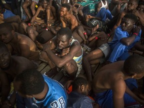 Sub saharan migrants sit on the deck of the vessel of Proactiva Open Arms after being rescued in the Mediterranean Sea, about 15 miles north of Sabratha, Libya on Tuesday, July 25, 2017. More than 120 migrants were rescued Tuesday from the Mediterranean Sea while 13 more --including pregnant women and children-- died in a crammed rubber raft, according to a Spanish rescue group. (AP Photo/Santi Palacios)