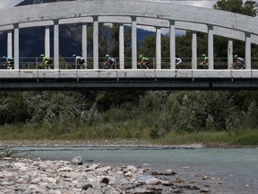 The pack rides on a bridge during the eighteenth stage of the Tour de France cycling race over 179.5 kilometers (111.5 miles) with start in Briancon and finish on Izoard pass, France, Thursday, July 20, 2017. (AP Photo/Peter Dejong)
