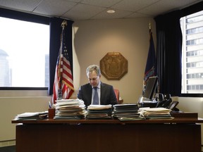 FILE- In this Feb. 17, 2017, file photo, New York State Attorney General Eric Schneiderman sits at his desk in his office in New York. Schneiderman's office considers Secretary of State Rex Tillerson a central figure in his expanding investigation into whether ExxonMobil misled investors about the impact of climate change. (AP Photo/Frank Franklin II, File)