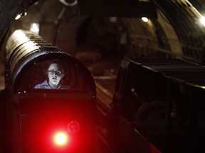 A passenger train rides through the Mail Rail tunnels that is included in the Postal Museum in London, Wednesday, July 26, 2017. London's newest tourist attraction is perfect for underground explorers. It's not ideal for the claustrophobic. A visit to Mail Rail, a subterranean train network that once carried millions of letters a day across the city, involves a cramped journey through dark tunnels 70 feet (21 meters) below the surface, on a very small train. It's atmospheric, but not roomy. (AP Photo/Frank Augstein)