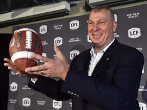 New CFL commissioner Randy Ambrosie tosses a football as he speaks during a press conference in Toronto on July 5.