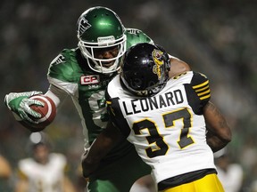 Saskatchewan Roughriders wide receiver Duron Carter (89) gets tangled up with Hamilton Tiger-Cats linebacker Will Smith (37) after making a grab during second half CFL football action in Regina on Saturday, July 8, 2017.