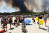 Sunbathers are evacuated from the beach in Le Lavandou, French Riviera, as plumes of smoke rise in the air from burning wildfires on Wednesday.