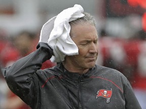Tampa Bay Buccaneers head coach Dirk Koetter towels off as rains associated with Tropical Storm Emily falls during an NFL football training camp practice Monday, July 31, 2017, in Tampa, Fla. (AP Photo/Chris O'Meara)