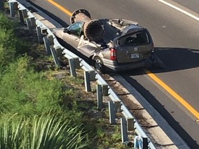 In this photo provided by the Florida Highway Patrol, a van is shown with a piece of scrap metal on its roof  in Orange County, Florida, on Saturday, July 15, 2017. The highway patrol said the scrap metal fell from a truck that had lost control and overturned on an overpass. The van driver and the driver of the semi had only minor injuries. (Florida Highway Patrol via AP)