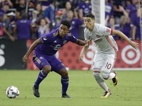 Orlando City's Cristian Higuita, left, moves the ball past Atlanta United's Miguel Almiron (10) during the first half of an MLS soccer match, Friday, July 21, 2017, in Orlando, Fla. (AP Photo/John Raoux)