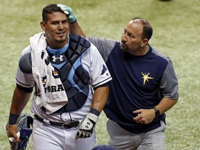 Tampa Bay Rays head athletic trainer Ron Porterfield, right, applies pressure to a cut on the head of Rays catcher Wilson Ramos who was struck by the broken bat of Baltimore Orioles' Ruben Tejada during the fifth inning of a baseball game Monday, July 24, 2017, in St. Petersburg, Fla. (AP Photo/Mike Carlson)