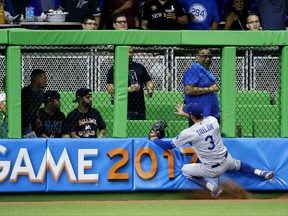 Los Angeles Dodgers left fielder Chris Taylor hits the wall after catching a ball hit by Miami Marlins' Dee Gordon during the first inning of a baseball game, Friday, July 14, 2017, in Miami. (AP Photo/Wilfredo Lee)