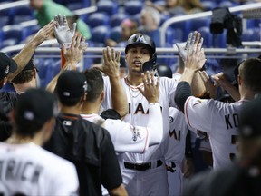 Miami Marlins' Giancarlo Stanton is congratulated by teammates after hitting a two-run home run during the first inning against the Philadelphia Phillies in a baseball game Monday, July 17, 2017, in Miami. (AP Photo/Wilfredo Lee)