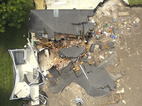 In this aerial photo, debris is strewn about after a sinkhole damaged two homes in Land O' Lakes, Fla. on Friday, July 14, 2017.