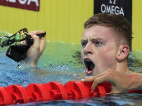 Britain's Adam Peaty celebrates after setting a new world record in a men's 50-meter breaststroke heat during the swimming competitions of the World Aquatics Championships in Budapest, Hungary, Tuesday, July 25, 2017. (AP Photo/Michael Sohn)