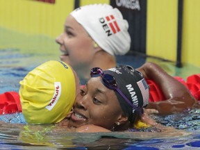 United States' Simone Manuel, right, is congratulated by Sweden's silver medal winner Sarah Sjostrom, left, and Denmark's bronze medal winner Pernille Blume after winning the gold medal in the in the women's 100-meter freestyle final during the swimming competitions of the World Aquatics Championships in Budapest, Hungary, Friday, July 28, 2017. (AP Photo/Michael Sohn)