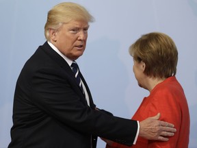 U.S. President Donald Trump, left, is welcomed by German Chancellor Angela Merkel on the first day of the G-20 summit in Hamburg, northern Germany, Friday, July 7, 2017. The leaders of the group of 20 meet July 7 and 8. (AP Photo/Michael Sohn)