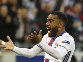 FILE - A Thursday, May 11, 2017 file photo of Lyon's Alexandre Lacazette reacting after his team scored their side's third goal during the second leg semi final soccer match between Olympique Lyon and Ajax in the Stade de Lyon, Decines, France. Arsenal signaled its intention to make an immediate return to the Premier League's elite by signing Lyon striker Alexandre Lacazette, one of Europe's most prolific players in recent years. Arsenal said on its website Wednesday that the 26-year-old Lacazette "has agreed to join us on a long-term contract, for an undisclosed fee." (AP Photo/Laurent Cipriani, File)