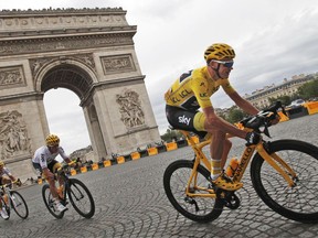 Chris Froome (right) passes by the Arc de Triomphe during the final stage of the Tour de France in Paris on July 23.