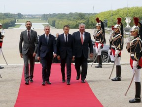 French President Emmanuel Macron, second right, is welcomed by French Prime Minister Edouard Philippe, left, National Assembly speaker Francois de Rugy, second left, and Senate speaker Gerard Larcher, as he arrives at the Versailles Palace, Monday, July 3, 2017. Macron will lay out his political, security and diplomatic priorities at an extraordinary joint session of parliament at the chateau of Versailles. (Philippe Wojazer, Pool via AP)