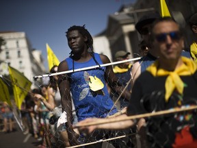 A demonstrator carries wire representing border razor wire fences, as he marches with others during a protest in support of migrant people seeking to enter Europe, in Madrid, Saturday, July 15, 2017. (AP Photo/Francisco Seco)