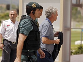 Former President of the Spanish Football Federation Angel Maria Villar, right, is lead by Spanish Civil Guard policemen to enter the Federation headquarters during an anti-corruption operation in Las Rozas, outside Madrid, Tuesday, July 18, 2017. Villar, FIFA's senior vice president and a long-time player in world soccer, was arrested Tuesday along with his son and two more federation executives in an anti-corruption investigation. (AP Photo/Francisco Seco)