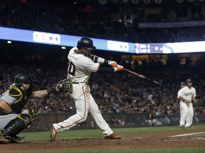 San Francisco Giants' Eduardo Nunez hits a two-run double in front of Pittsburgh Pirates catcher Francisco Cervelli during the fourth inning of a baseball game in San Francisco, Tuesday, July 25, 2017. (AP Photo/Jeff Chiu)