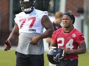 Atlanta Falcons defensive tackle Ra'Shede Hageman and running back Devonta Freeman walk to the field for NFL football training camp on Thursday, July 27, 2017, in Flowery Branch, Ga. (Curtis Compton/Atlanta Journal-Constitution via AP)