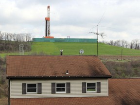 FILE – In this April 1, 2016, file photo, a shale gas drilling rig, background, rises above a private home, foreground, in the Washington County city of Washington, Pa. Natural gas producers drilled more than twice as many shale wells in the first half of 2017 compared to the same period last year. One big reason is that natural gas prices have recovered from 20-year lows, nearly doubling since last year. (AP Photo/Michael Rubinkam, File)