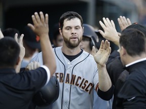 San Francisco Giants first baseman Brandon Belt is greeted in the dugout after scoring during the fourth inning of the team's baseball game against the Detroit Tigers, Wednesday, July 5, 2017, in Detroit. (AP Photo/Carlos Osorio)