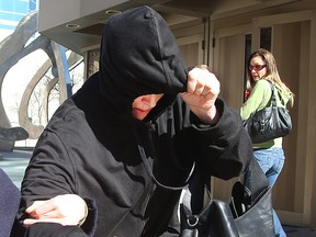 Andrea Giesbrecht tries to hide from the media as she leaves the Law Courts in Winnipeg, Man., on April 21, 2016.