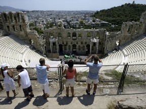 FILE - In this Wednesday, July 12, 2006 file photo, tourists take photographs of the Herod Atticus theater, also famous for the events of the Athens Festival. Organizers of Greece's most prestigious summer cultural festival say on Tuesday, July 4, 2017, they will honor overtime payment demands by workers whose strike already forced the cancellation of two theatrical performances. (AP Photo/Thanassis Stavrakis, File)