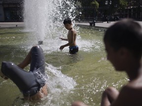 Children play in a fountain in a square outside the Athens Town Hall in Athens, on Friday, June 30, 2017. A summer heatwave has hit Greece, with temperatures reaching a high of 44 degrees Celsius (111 Fahrenheit) in Athens Friday, and is expected to last over the weekend. (AP Photo/Petros Giannakouris)