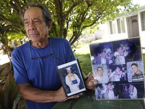 In this Monday, July 10, 2017 photo, Clifford Kang, father of soldier Ikaika E. Kang, poses with photo of his son in Kailua, Hawaii.  Ikaika E. Kang, an active-duty U.S. soldier, was arrested over the weekend on terrorism charges that accuse him of pledging allegiance to the Islamic State group and saying he wanted to "kill a bunch of people." (Bruce Asato/The Star-Advertiser via AP)