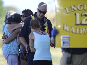 In this Saturday, July 29, 2017, photo, friends or relatives of the victims of the small plane crash arrive at an Honolulu Fire Department helicopter staging area in Kunia, Hawaii. Federal investigators haven't yet determined what caused the plane to crash in an inaccessible mountainous area on the island of Oahu. Hutton and his three passengers died in the crash. (Bruce Asato/The Star-Advertiser via AP)
