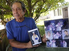 In this July 10, 2017 photo, Clifford Kang, father of soldier Ikaika E. Kang, poses with photos of his son in Kailua, Hawaii. Ikaika E. Kang, an active-duty U.S. soldier, was arrested over the weekend on terrorism charges that accuse him of pledging allegiance to the Islamic State group and saying he wanted to "kill a bunch of people." Ikaika E. Kang is scheduled to appear in federal court for an arraignment Monday, July 24, 2017. (Bruce Asato/The Star-Advertiser via AP)
