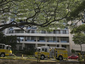 Firefighters work at the scene of a multiple-alarm fire at a high-rise apartment building, Friday, July 14, 2107, in Honolulu. (AP Photo/Marco Garcia)
