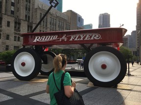 An oversized Radio Flyer wagon is displayed in Pioneer Court on North Michigan Avenue in downtown Chicago, to celebrate the company's 100th anniversary on Thursday, July 13, 2017. (Mark Hume/Chicago Tribune via AP)