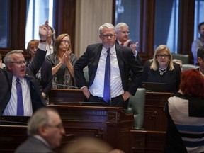 Illinois House Minority Leader Jim Durkin, center, R-Western Springs, announces, "I want this done today," as the Republican side of the aisle erupts in applause, on the House floor after Illinois Speaker of the House Michael Madigan said that the Illinois House will be in session Sunday at the Illinois State Capitol Saturday, July 1, 2017, in Springfield, Ill. A $36.5 million plan to rebuild Illinois' crumbling finances passed a critical test Friday, but no deal was reached before the midnight deadline. (Justin Fowler /The State Journal-Register via AP)