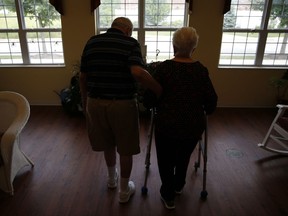 Chuck Schwarz, left, takes walk with his wife Cathy at Heritage Woods of South Elgin, Friday, June 30, 2017, in South Elgin, Ill. Medicaid Americans 65 and order and the disabled make up about a quarter of Medicaid recipients but account for two-thirds of its expenditures. (AP Photo/Nam Y. Huh)