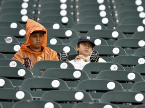 Jacob Salamon, 11, left, and his brother Jeremiah, 8, sit in their seats in a steady rain after it was announced that a baseball game between the Detroit Tigers and the Cleveland Indians was postponed, Friday, June 30, 2017 in Detroit. The brothers had traveled from Austin, Texas, with their family to watch the Tigers. (AP Photo/Lon Horwedel)
