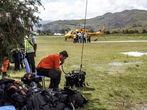 Members of the National Search and Rescue Agency (BASARNAS) uses his radio during the rescue operation for the crashed Association of Mission Aviation (AMA) plane at the airport in Wamena, Papua province, Indonesia, Thursday, July 6, 2017. Rescuers have discovered and evacuated all bodies of five people onboard a small plane that crashed in a remote area in Indonesia's easternmost province of Papua. (AP Photo/Gerry Kossay)