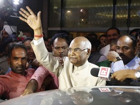 FILE- In this June 19, 2017, file photo, Ram Nath Kovind, center, waves to media upon arrival at the airport in New Delhi, India. Kovind, 71, a Hindu nationalist leader has been elected India's new president, a largely ceremonial position. (AP Photo/Tsering Topgyal, file)